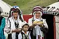 Kyrgyz women and child offering bread and salt on the opening of the National Horse Games