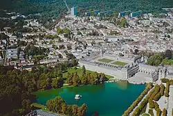 Aerial view of the palace and the centre of the commune, with a portion of its forest