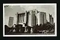 An old black and white photo styled as a postcard, with a close-up of the side of the Cardston Alberta temple. Two braziers are seen to the side, along with climbing ivy up a side wall in the foreground.