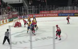 Several ice hockey players in red and yellow jerseys
