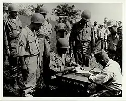 Lt. Col. Sylvester Del Corso, commander of the 1st Battalion, 145th Infantry, receives the surrender of Japanese forces on the Philippine Island of Luzon