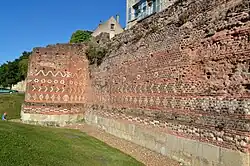 Color photograph of an ancient wall with stones forming geometric patterns.