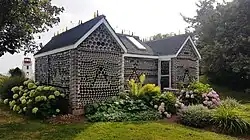 Exterior view of a small house made of glass bottles