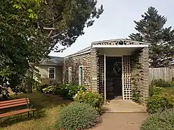 Exterior view of a small building made of glass bottles