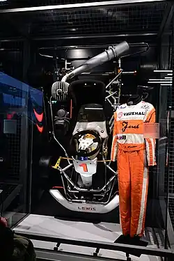 A kart and jumpsuit in display.