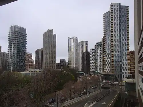The emerging cluster in Lewisham also known as Lewisham Gateway, and first Borough of Sanctuary,[519] which includes 209 Connington Road Tower at 117&nbsp;m tall which is the white building in the centre and Lewisham Exchange at 105&nbsp;m tall to the left of it. All of the high-rises shown in this picture are residential with the exception of the grey building shown in the immediate right foreground which was formerly the London offices of Citigroup until they relocated to 25 Canada Square at Canary Wharf in 2001