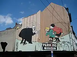 Color photograph of a mural showing the Quick and Flupke characters in the streets of Brussels.