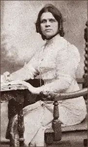 Black and white photo of Luisa Capetillo sitting at a writing desk