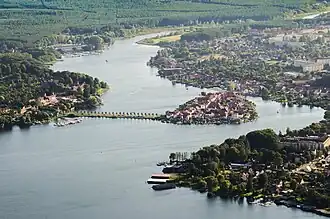A body of water surrounded by greenery and human settlements.