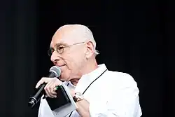 Marek Lieberberg turns sideways while speaking into a microphone