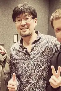 Music composer Masafumi Takada gives a thumbs up in 2014.