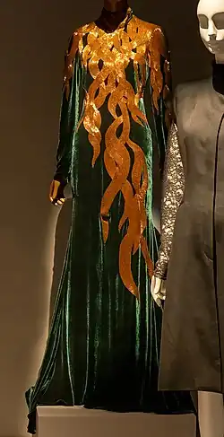 Floor-length green velvet gown with long sleeves, with bronze beading resembling hair