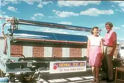 Marjorie and Aden Meinel stood by a linear parabolic thermal collector