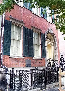 A side view of the facade as seen from Fourth Street. The first-floor windows, raised slightly above the sidewalk, are to the left of the main doorway.
