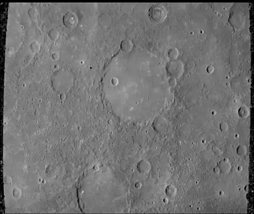 The Schubert basin, 190&nbsp;km (120&nbsp;mi) in diameter, filled by smooth plains. The basin's hummocky rim is partly degraded and cratered by later events.