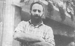 Black and white photo of man standing with arms crossed
