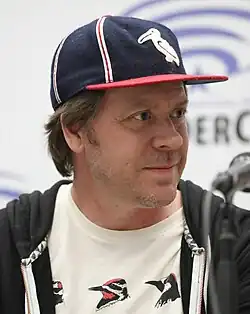 a man wearing a baseball cap stares to his left