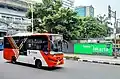 Minitrans bus near Blok-M bus terminal, with the ASEAN headquarters building in the background.