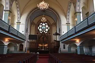 Interior view showing pulpit, altar, and chandeliers