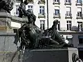 Bronze statue on a marble base; water gushes from an amphora