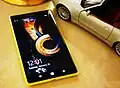 The Nokia Lumia 1520 next to a 1:18 scale model car for comparison.
