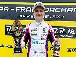 Piastri with his trophy and champagne after winning the 2019 Formula Renault Eurocup Spa-Francorchamps round