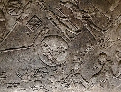 Goddess Isis holding a baboon (the god Thoth) by the tail.