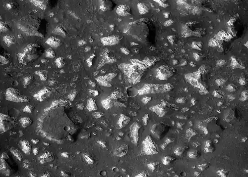 Deep-basin deposits from the floor of Eridania Sea. The mesas on the floor are there because they were protected against intense erosion by deep water/ice cover. CRISM measurements show minerals may be from seafloor hydrothermal deposits.