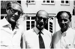 Poul Baastrup, John Cade, and Mogens Schou standing together outside.