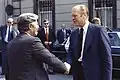 Gerald Ford escorts Helmut Schmidt, Chancellor of the Federal Republic of Germany, to his limousine after a luncheon meeting at the American Embassy Residence during the 1975 Brussels NATO summit