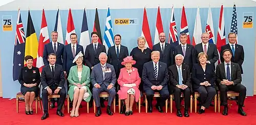 A seated portrait of Prince Charles, Queen Elizabeth II, and various world leaders