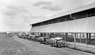 Bags of wheat being delivered by motor vehicles at the grain shed, 1934