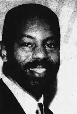 Black-and-white headshot of Abernathy beaming in a suit