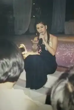 Velasquez singing while sitting by the stairs of the main stage
