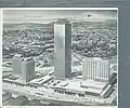 Original architectural rendering shows discrete buildings separated by outdoor plazas
