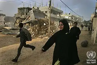 Armed Israeli bulldozer destroying a Palestinian home in Gaza during the Second Intifada, 2001