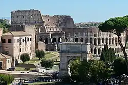 View of the Arch of Titus in the foreground with the Colosseum behind it in Rome