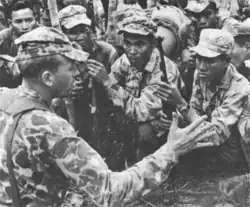 SAF adviser briefing a Montagnard strike force wearing frog skin