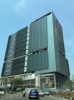 A large office building with a bluish-green glass facade.