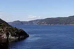 A very wide river flows between low lines of hills.