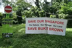 A suspended banner reading "Save Our Singapore" and "Save Bukit Brown"