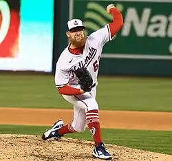 Sean Doolittle, with his left arm above his head, delivering a pitch in a white Washington Nationals uniform