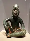 Seated shaman in ritual pose-shaped pendant (Olmec); 9th-5th century BC; serpentine and cinnabar; height: 18.5&nbsp;cm; Dallas Museum of Art (Dallas, Texas, US)[70]