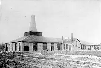 old photo of a brick factory with one big smokestack