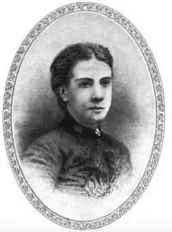 19th-century oval B&W portrait photo of a woman with her hair in an up-do, wearing a dark, fitted blouse.