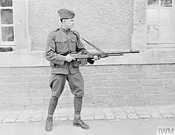 U.S. soldier standing outdoors in France holding and demonstrating a Browning Automatic Rifle during November 1918.