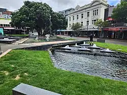 Photo of grass, a pool of water and water fountains