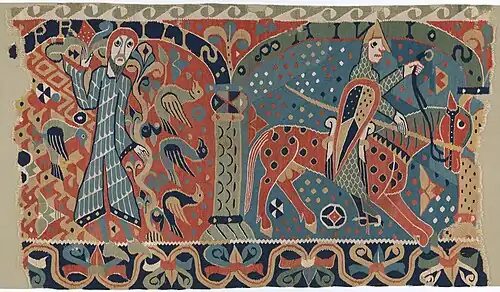 Vividly colored woven tapestry fragment depicts two men. On the left, a standing man is surrounded by birds. On the right, an armored man rides a horse.