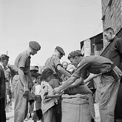 British soldiers passing out supplies to the residents of Cheung Chau. During Japanese rule, Hong Kong suffered from malnutrition due to lack of food supplies, and the British needed to ship in supplies to relieve the situation.[12]