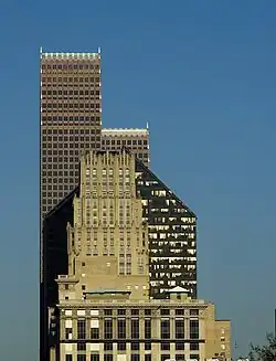 Three skyscrapers visually overlap each other. The simple, rectangular tiers of JPMorgan Chase Building contrast with the five-sided tower of the Pennzoil building and the stepped rows of spires of the Bank of America building.